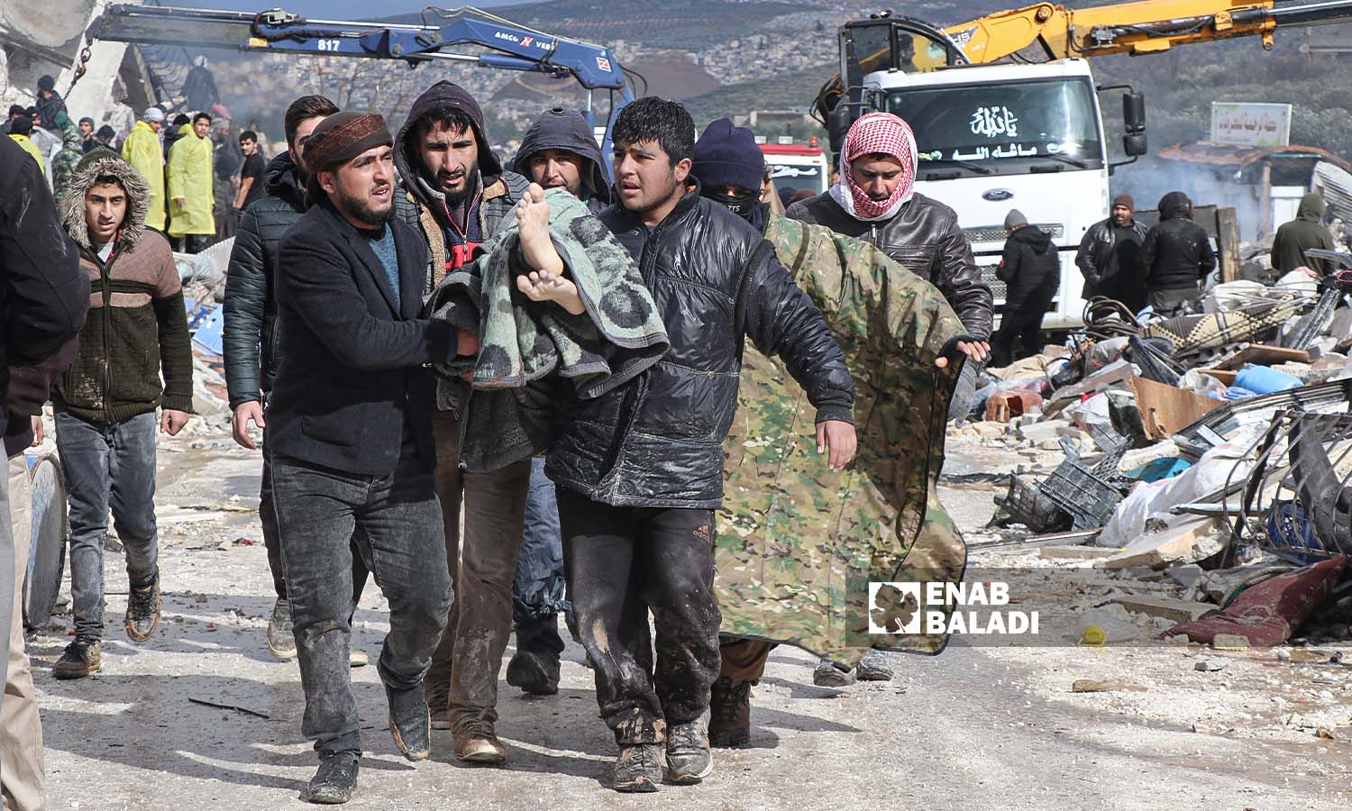 متطوعون في حارم يحملون أحد ضحايا الزلزال الذي ضرب مناطق شمال غربي سوريا - - 6 شباط 2023 (/ محمد نعسان دبل)