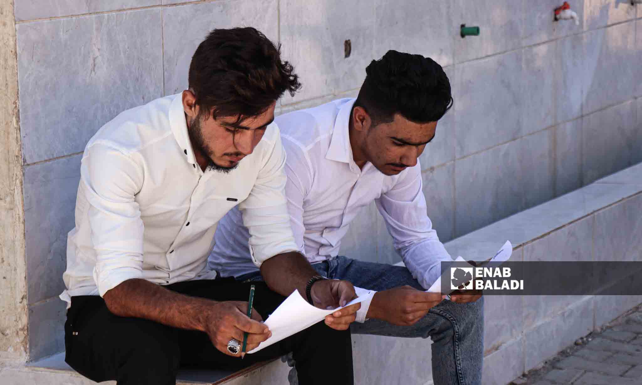 طالبان يراجعان معلوماتهم قبل الدخول لقاعة الامتحان - 5 من تموز 2023 (/ حسين شعبو)