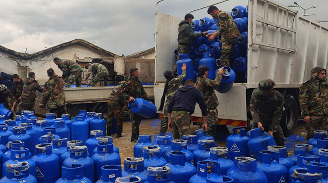 من عملية جمع أسطوانات الغاز التي جرفتها السيول بمحافظة اللاذقية غربي سوريا- 17 من شباط 2024 (سانا)