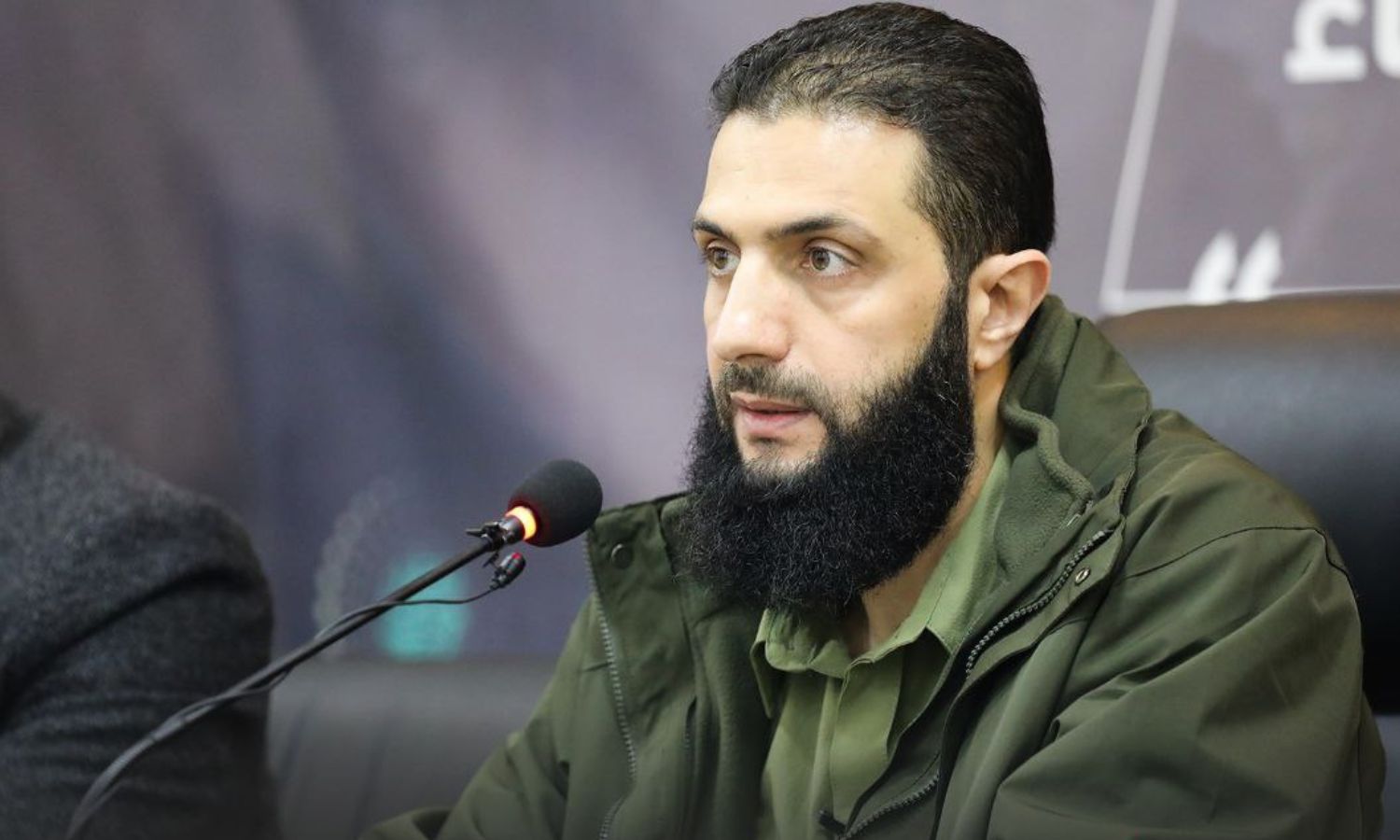 القائد العام لـ"هيئة تحرير الشام"، "أبو محمد الجولاني" خلال مؤتمر لإطلاق حملة دعم لمخيمات شمالي سوريا- 15 من كانون الأول 2022 (أمجاد)