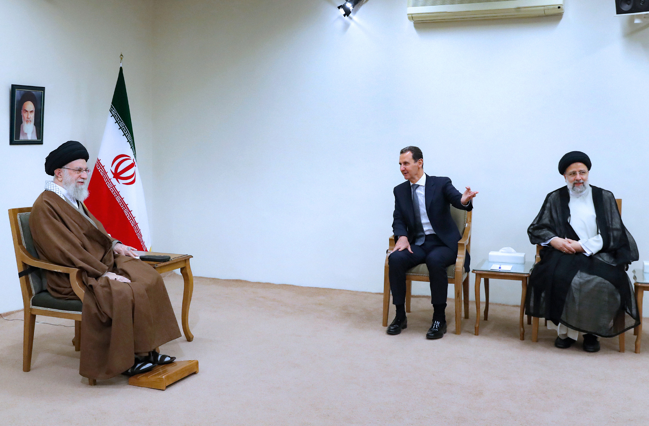 من اليمين، الرئيس الإيراني إبراهيم رئيسي، ورئيس النظام السوري بشار الأسد، والمرشد الأعلى الإيراني آية الله الخميني في طهران- 8 من أيار 2022 (AP)