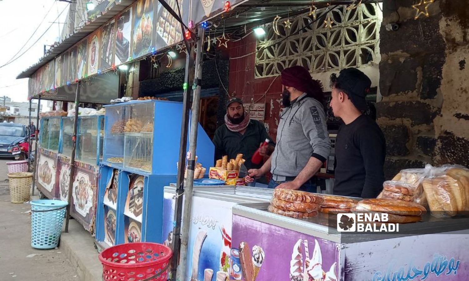 يبحث السكان في مدينة طفس بدرعا عن أسعار مقبولة لحلويات عيد الفطر - 24 من آذار 2024 (/ حليم محمد)